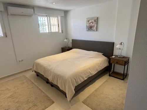 ein Schlafzimmer mit einem Bett und einem Fenster in der Unterkunft Ruime woning aan golfbaan in Rojales