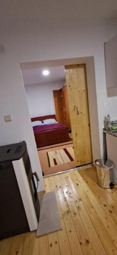 Cette chambre comprend une cuisine et une porte menant à une chambre. dans l'établissement Sofia apartman, à Kolašin