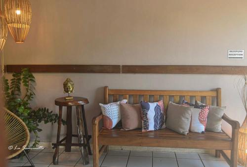 a wooden bench with pillows on it in a room at Pousada Serra Grisante in Lençóis