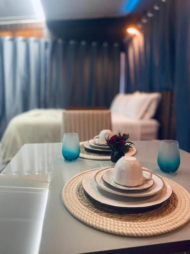 a table with two plates and two blue glasses at Chalé Pedras in Garanhuns