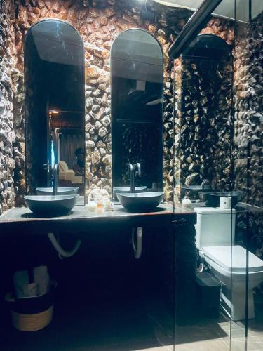 a bathroom with two sinks and a toilet at Chalé Pedras in Garanhuns