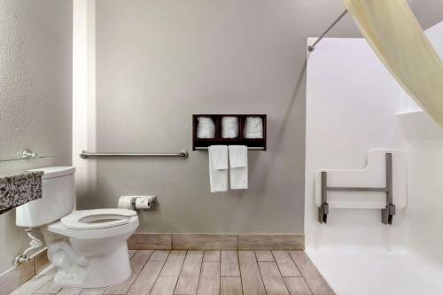 a bathroom with a toilet and a sink and towels at Best Western Casino Inn in Vinton