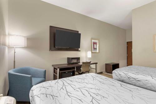 a hotel room with a bed and a chair and a tv at Best Western Casino Inn in Vinton