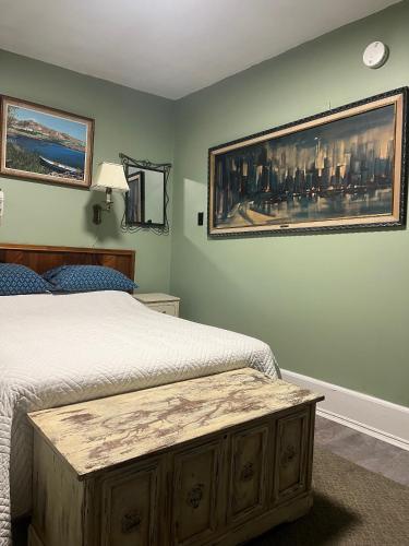 a bedroom with two beds and a painting on the wall at Pring Guesthouse in Hamilton