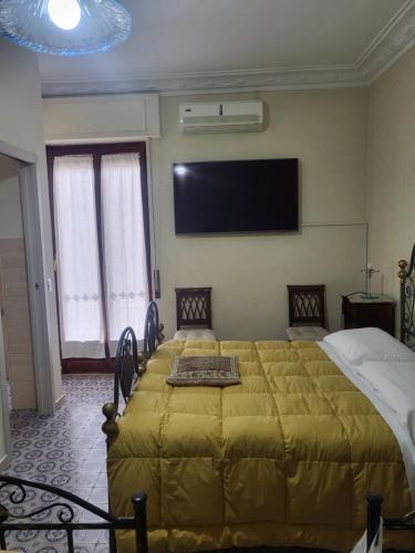 a bedroom with a large bed and a flat screen tv at Maison Manni' B&B in Soverato Marina