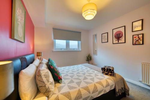 a bedroom with a bed with pillows on it at Modern 2 Bed Flat with Free Parking in Glasgow