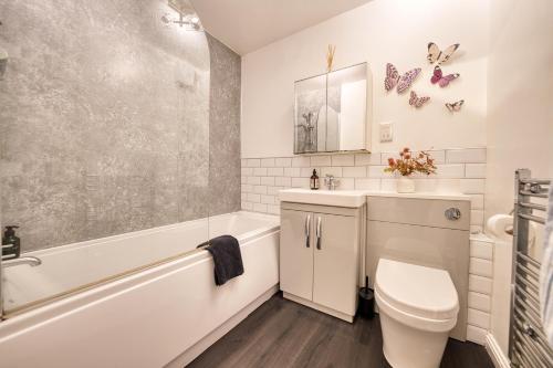a bathroom with a toilet and a tub and a sink at Modern 2 Bed Flat with Free Parking in Glasgow