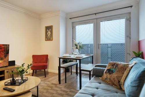 a living room with a couch and a table at Modern 2 Bed Flat with Free Parking in Glasgow