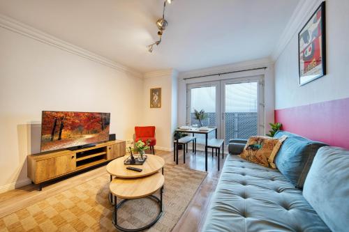 a living room with a blue couch and a table at Modern 2 Bed Flat with Free Parking in Glasgow