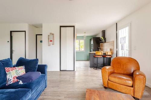 un salon avec un canapé bleu et une chaise dans l'établissement La maison du Bout du Monde, Jacuzzi, Climatisation, 4 chambres, Plage à 600M et Phare à 1Km, à Chassiron