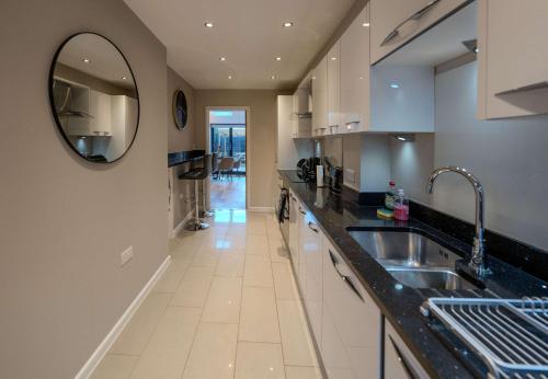 a kitchen with a sink and a mirror on the wall at Beautiful 2 Bedroom Home in Cambridge