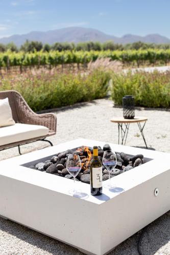 a table with two wine glasses and a bottle of wine at Hotel Andana Winery & Spa in Valle de Guadalupe