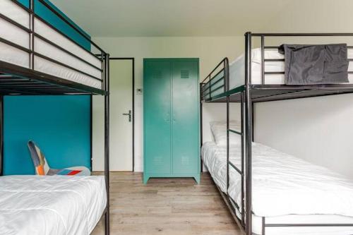 ChassironLa maison du Bout du Monde, Jacuzzi, Climatisation, 4 chambres, Plage à 600M et Phare à 1Km的带两张双层床和蓝色门的房间