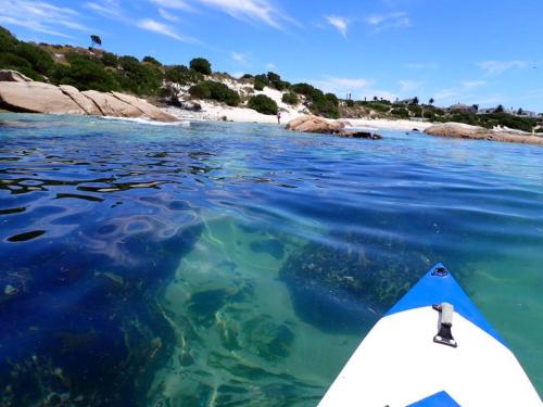 a kayak in the water next to a beach at Villa on the Bay in Stompneusbaai