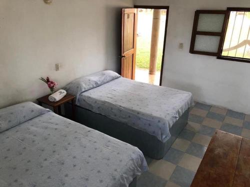 a bedroom with two beds and a phone on a table at Cabañas Edda in Puerto Escondido