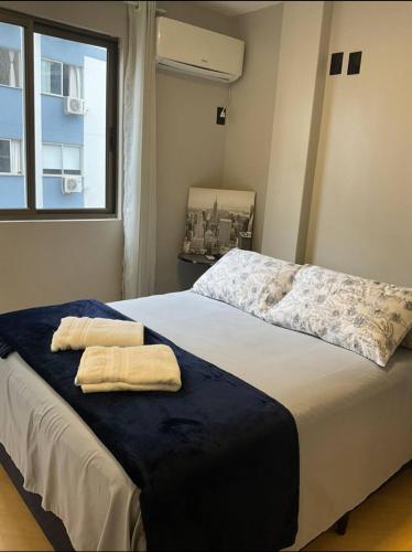 a bedroom with a bed with two towels on it at Ape Av Brasil pertinho do mar in Balneário Camboriú