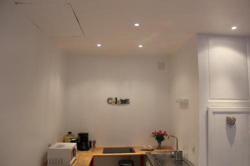 a kitchen with white walls and a counter top at Charmante Maison De Pêcheur in Honfleur