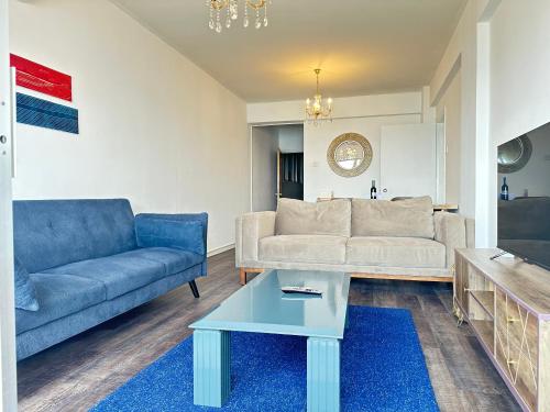Una sala de estar con un sofá y una mesa de café. en 2BR SEAFRONT Apt in city center with community pool, en Lárnaca