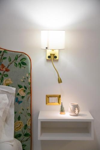 a lamp on a wall next to a bed at Suite Old Town Sorrento in Sorrento