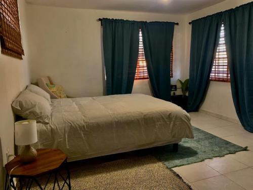 una camera da letto con tende blu, un letto e un tavolo di En el Malecon de Puerto Peñasco a Puerto Peñasco