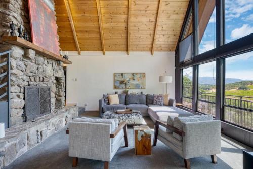 a living room with a stone fireplace and a couch at Kenwood Vista by AvantStay 7acres w Pool Fire Pit Vineyard Views in Kenwood