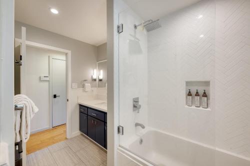 a white bathroom with a shower and a sink at Kenwood Vista by AvantStay 7acres w Pool Fire Pit Vineyard Views in Kenwood