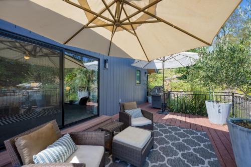 an outdoor patio with chairs and an umbrella at Kenwood Vista by AvantStay 7acres w Pool Fire Pit Vineyard Views in Kenwood