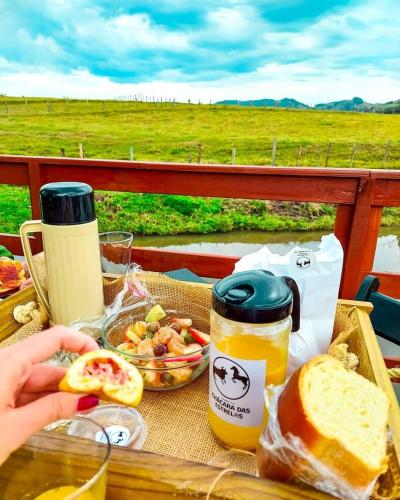 a picnic table with a sandwich and a bowl of food at Chalé Rústico com Hidromassagem e Piscina in Imaruí