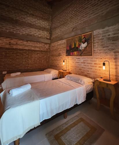 two beds in a room with two lamps and two beds sidx sidx sidx at LORETO GUEST HOUSE YAYETOPa in Loreto