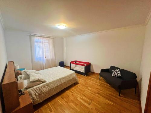 a bedroom with a bed and a couch in it at Casa Besugo in Sesimbra