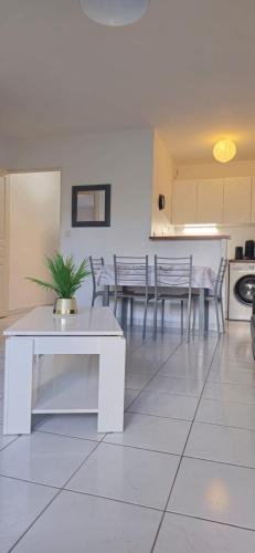 un salon avec une table et des chaises blanches dans l'établissement Lovely & Cosy Appartement à Disneyland, à Montévrain