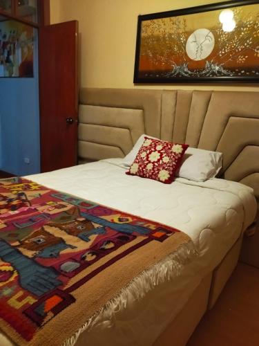 a bed with a quilt on it in a bedroom at Alojamiento Místico in Ayacucho