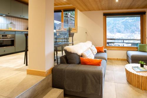 une cuisine et un salon avec un canapé et une table dans l'établissement Stylish 1 bed apartment with a view to die for!, à Morzine