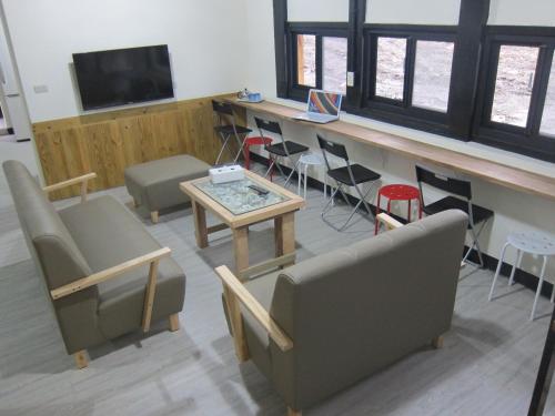 a living room with couches and a table and chairs at Runners' House Taitung in Changbin