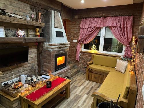 a living room with a couch and a fireplace at Matanovi Dvori in Slavonski Brod