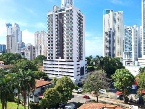 a tall white building in the middle of a city at La Cresta by Wynwood House in Panama City