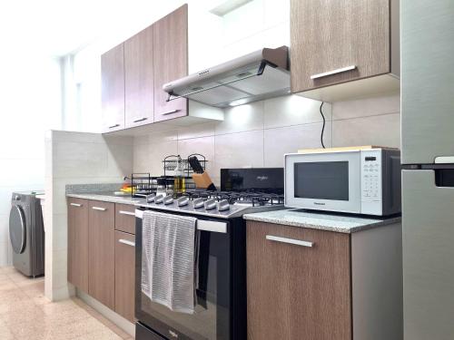 a kitchen with a stove and a microwave at La Cresta by Wynwood House in Panama City