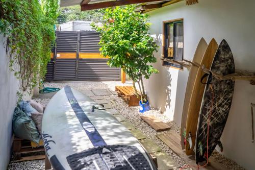 a surfboard is sitting outside of a room with a house at The Cafecito Surfhouse - Santa Teresa in Santa Teresa Beach