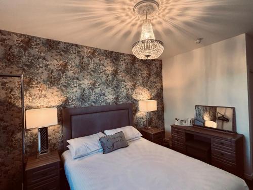 a bedroom with a large bed and a chandelier at The Mill House Hotel in Buckie