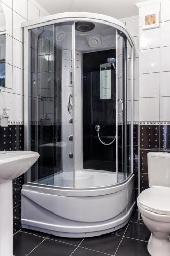 a bathroom with a shower with a toilet and a sink at Robert Hotel in Dragobrat