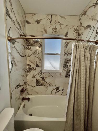 a bathroom with a bath tub and a window at Villa de Siglo-Century Villa in Abilene
