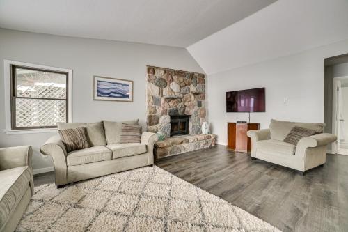 a living room with two couches and a stone fireplace at Dock and Views Lake Mitchell Home in Cadillac! in Cadillac