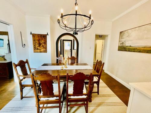 a dining room with a table and a chandelier at Villa de Siglo-Century Villa in Abilene