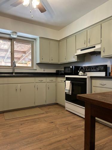 a kitchen with white cabinets and a stove top oven at The House On Kings Corner in Mansfield