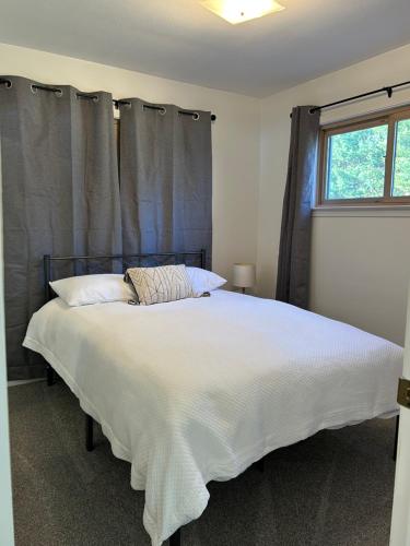 a bedroom with a large white bed with a window at The House On Kings Corner in Mansfield
