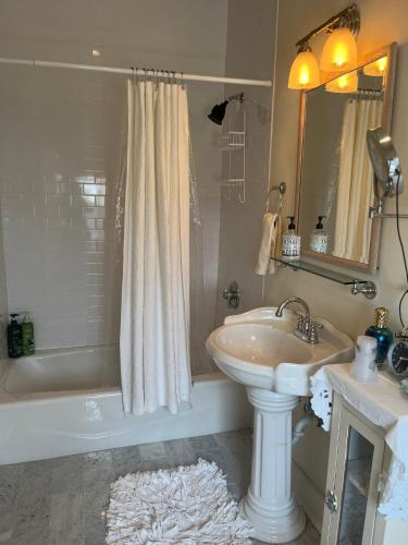 a bathroom with a sink and a shower and a tub at The Happy House in New Orleans