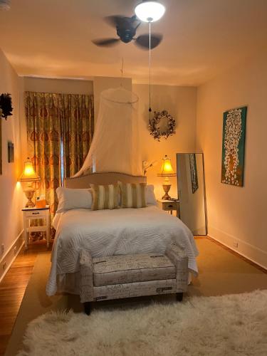 a bedroom with a large bed with a ceiling fan at The Happy House in New Orleans