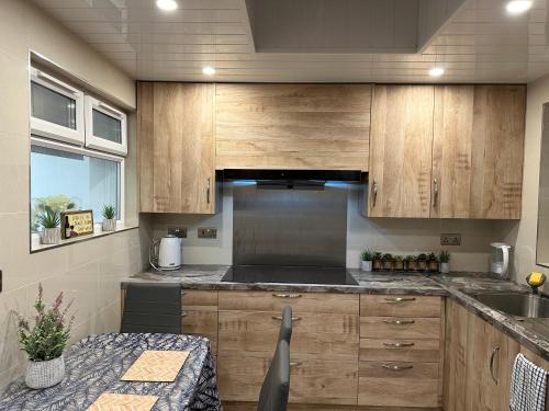 a kitchen with wooden cabinets and a table at SONG House in London