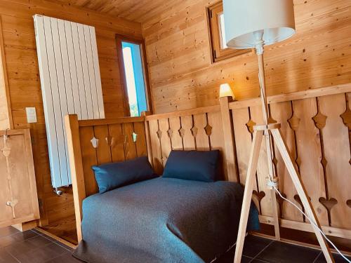 Ce lit se trouve dans un dortoir en bois doté d'une lampe. dans l'établissement Appartement 3 chambres au doux soleil, aux Gets