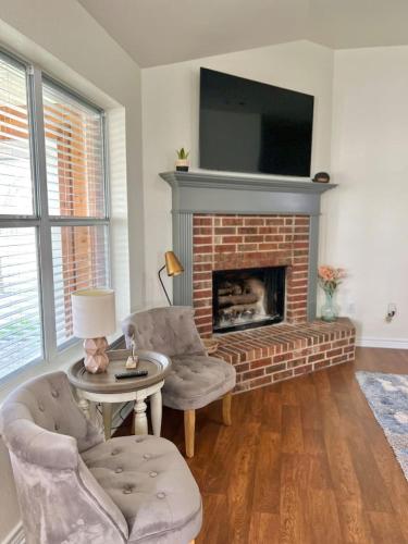 a living room with two chairs and a fireplace at Pecan Place Rustic Charm Temple Texas in Temple